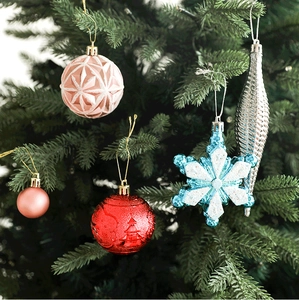 Detail of diverse Christmas ornaments including pink embossed balls and blue glitter snowflakes
