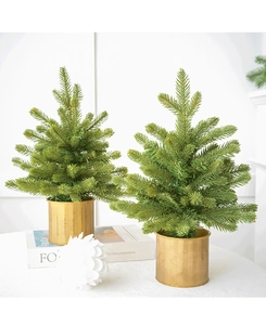 Detailed view of two faux mini Christmas trees in gold brushed metal pots for decor