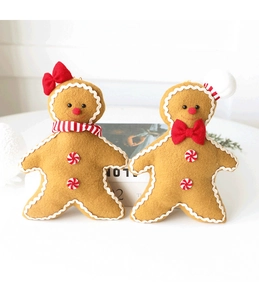 Close-up of plush gingerbread man Christmas ornaments with chef hat and striped scarf