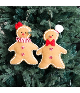Close-up of gingerbread man ornaments with festive scarves on a green Christmas tree