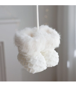 Close-up of white plush Christmas boot ornaments with woven texture and faux fur trim