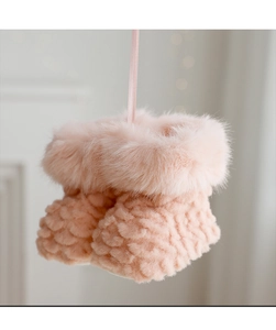 Close-up of pink knit Christmas boot ornament with faux fur trim and ribbon detail