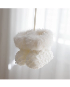 Macro shot of white knitted Christmas boot ornament with fluffy faux fur hanging details