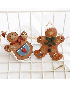 Detail von handbemalten Lebkuchenmann-Anhängern aus Harz mit Glitzer und Juteseil-Aufhängern