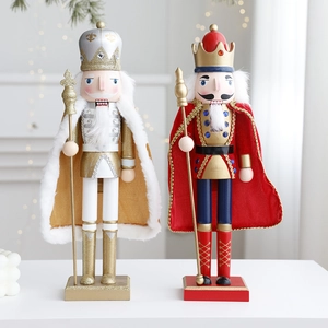 Wooden nutcracker soldier figurines with festive cloaks on a white pedestal