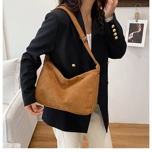 Close-up of brown suede hobo bag with adjustable wide strap for daily commute