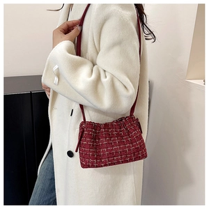 Details der roten Tweed-Schultertasche an einem Model in einem weißen Mantel