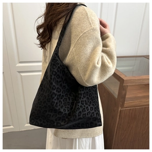 Detail of black leopard print tote bag showing velvet texture and hobo drape on shoulder