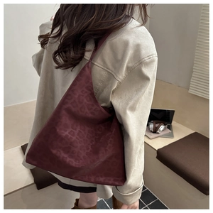 Detail of burgundy leopard print tote bag showing glossy texture and spacious silhouette