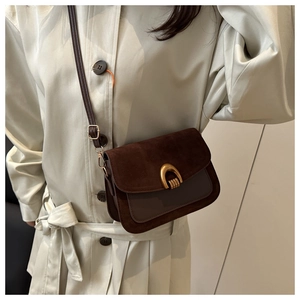 Detail of vintage dark brown crossbody bag with suede flap and gold U-shaped metal buckle
