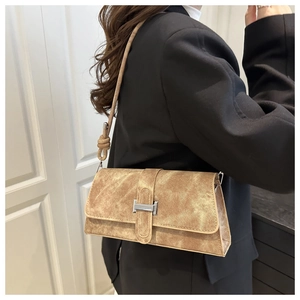 Close-up of khaki textured baguette bag featuring a metallic H buckle and knotted strap