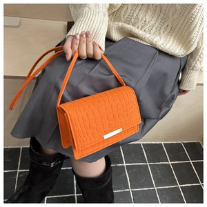 Gros plan détaillé du sac orange vif en similicuir avec une texture crocodile élégante