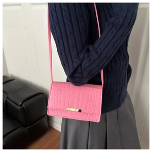 Détail du sac à bandoulière rose fuchsia à motif croco avec fermoir doré métallique