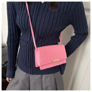 Vue détaillée du mini sac bandoulière rose à motif crocodile et finitions dorées