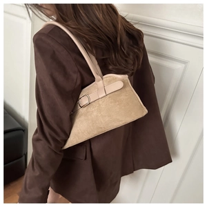 Detail of earthy brown suede shoulder bag with metallic buckle and slim leather strap