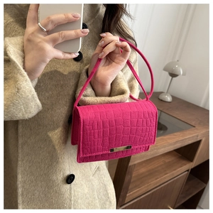Détail du sac à main fuchsia en similicuir crocodile avec boucle dorée et fine bandoulière