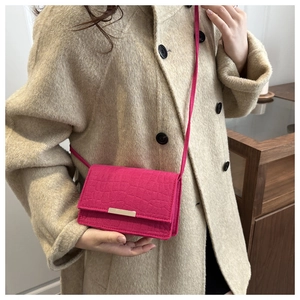 Détail du mini sac bandoulière fuchsia effet crocodile avec boucle en métal doré