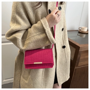 Détail du sac bandoulière fuchsia à motif crocodile avec fermoir métallique doré chic