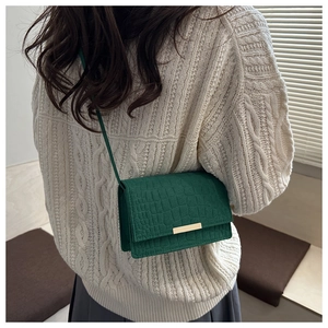 Détail du sac à bandoulière vert foncé motif crocodile avec boucle en métal doré chic