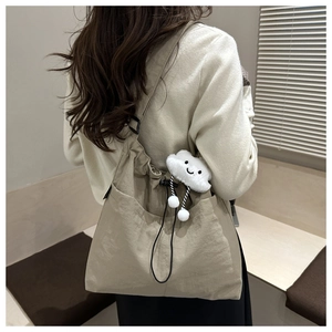 Detail of khaki nylon tote bag with drawstring closure and cute cloud plush charm