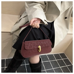 Dettaglio della borsa leopardata bordeaux con chiusura rotante in metallo dorato