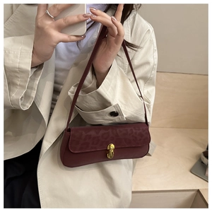 Détail du sac baguette bordeaux avec rabat léopard et boucle métallique dorée