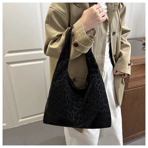 Close-up of leopard print tote bag styled with a beige trench coat for a retro look