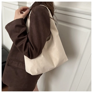 Detail of minimalist cream tote bag showing supple matte texture and large capacity