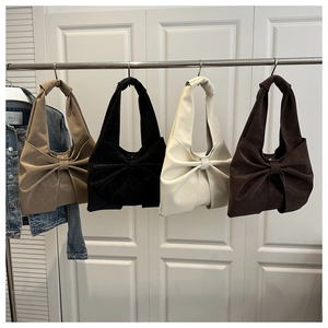 Detail of bow-shaped pleated tote bags in khaki, black, cream, and dark brown colors