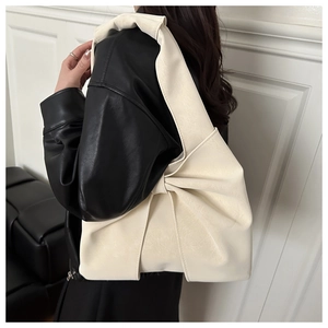 Détail de sac à bandoulière en cuir crème avec design minimaliste à nœuds pliés