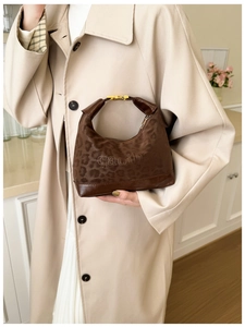 Dettaglio della borsa leopardata vintage con logo a rilievo e fibbia dorata