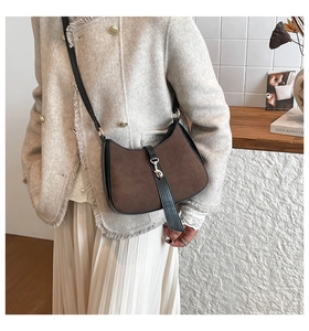 Detail of vintage suede crescent bag with gold metal buckle and leather strap