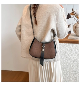 Detail of vintage suede baguette bag with brown nubuck, black trim and gold hook hardware