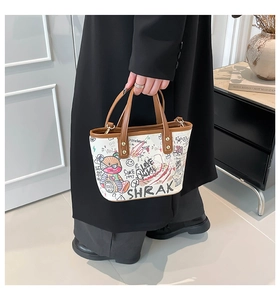 Détail d'un petit sac cabas en toile blanche avec graffitis colorés et anses en cuir