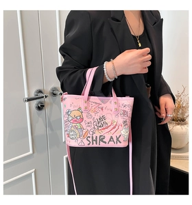 Détail du sac cabas rose avec art graffiti porté par un mannequin en blazer noir