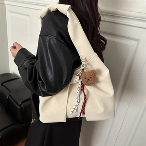 Creamy white oversized PU leather tote bag with a plush bear charm and woven rope detail