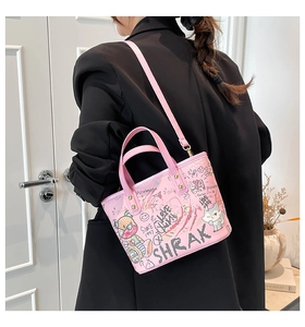 Détail du sac à main rose avec graffiti d'ours et accessoires métalliques dorés