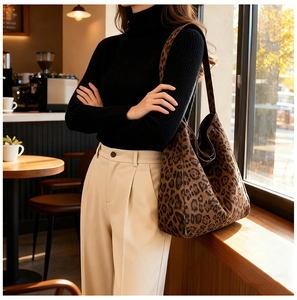 Detailed view of the leopard print tote bag fabric and pattern in a cozy cafe setting