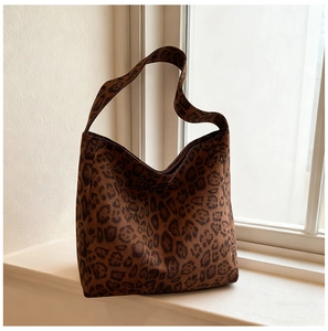 Close-up of leopard print tote bag with soft faux suede texture and wide shoulder strap
