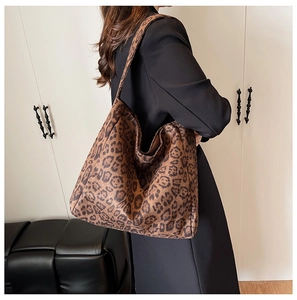 Close-up of leopard print tote bag texture and wide strap on model shoulder