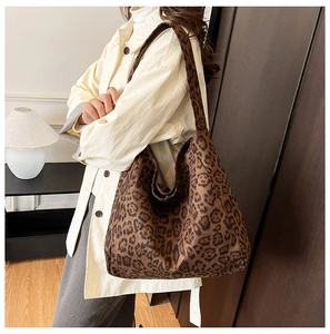 Side view of leopard print tote bag worn by model, showing soft texture and large capacity