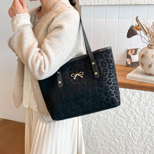 Fashionable black leopard print tote bag with gold bow clasp and shoulder strap
