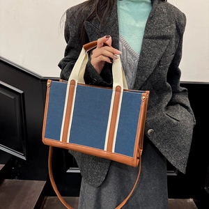 Retro denim tote bag with leather trim and wide straps for casual autumn styling