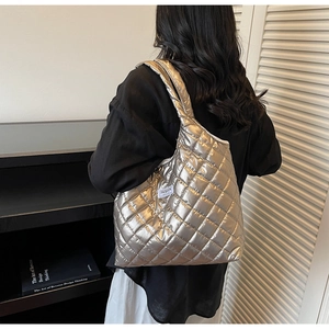 Detail der silbernen gesteppten Tragetasche mit Metallic-Effekt und Fashion-Etikett