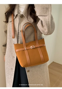 Detail of caramel retro tote bag showing textured fabric and leather strap in soft light