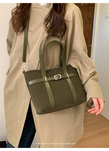 Macro view of olive green textured fabric tote bag with elegant silver buckle detail