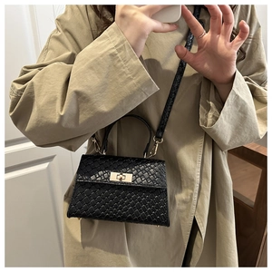 Détail du petit sac carré noir à motif crocodile avec fermoir rotatif doré élégant
