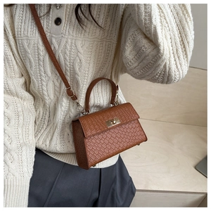 Detail of brown snakeskin texture faux leather bag with elegant metal twist lock closure