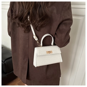White crocodile pattern square bag shown as a crossbody on a brown blazer outfit