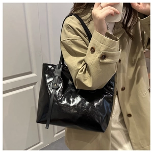 Chic black patent leather tote bag styled with a khaki trench coat in an OOTD mirror selfie